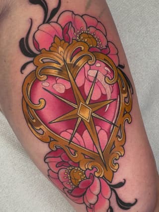 Ornate gold frame with central star containing pink heart surrounded by red flowers with yellow stamens on upper arm.